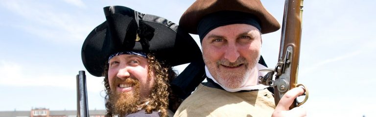 Two actors with colonial costumes with old guns