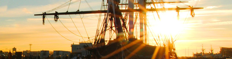 Sunset shinning through a ship overlooking Boston Skyline