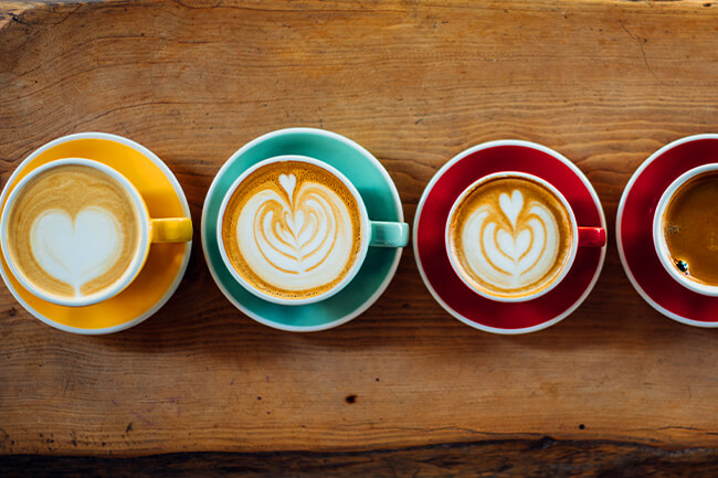 Specialty coffee with foam art served in colorful cups