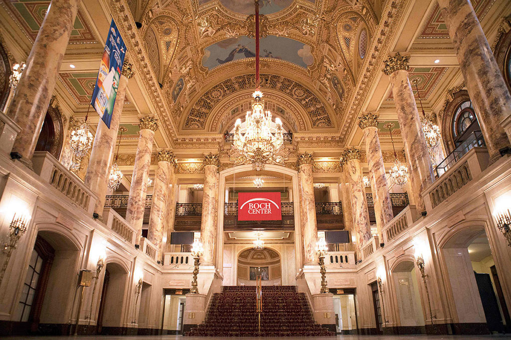 picture of boch center lobby featuring two floors, a set of carpeted stars, ornate walls and ceiling, a hanging crystal chandelier, and columns on second floor this winter in Boston