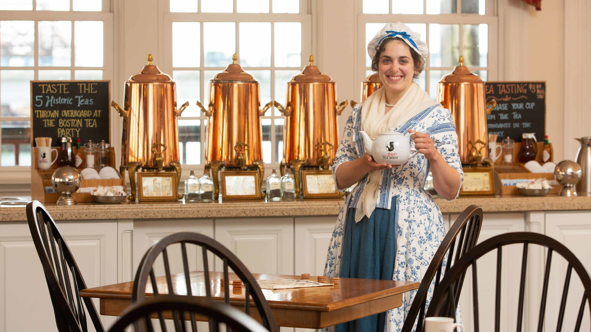 cast member in colonial outfit holding tea pot at abigail's tea room in boston